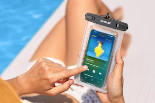 someone holding a waterproof phone pouch next to a pool