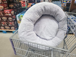 Large grey donut pet bed in a cart