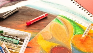 oil pastels and a drawing on a table