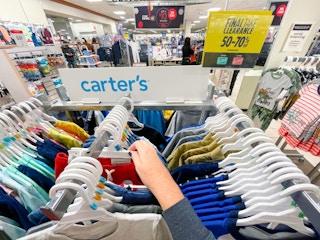hand looking through baby clearance apparel rack