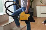 a woman carrying a vacuum
