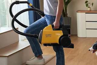 a woman carrying a vacuum