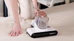 a person using a mattress vacuum 
