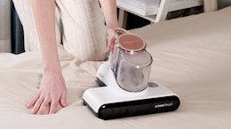 a person using a mattress vacuum 