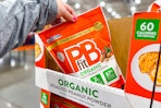 hand grabbing a bag of pbfit peanut powder