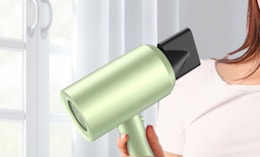 a hand holding a green hair dryer