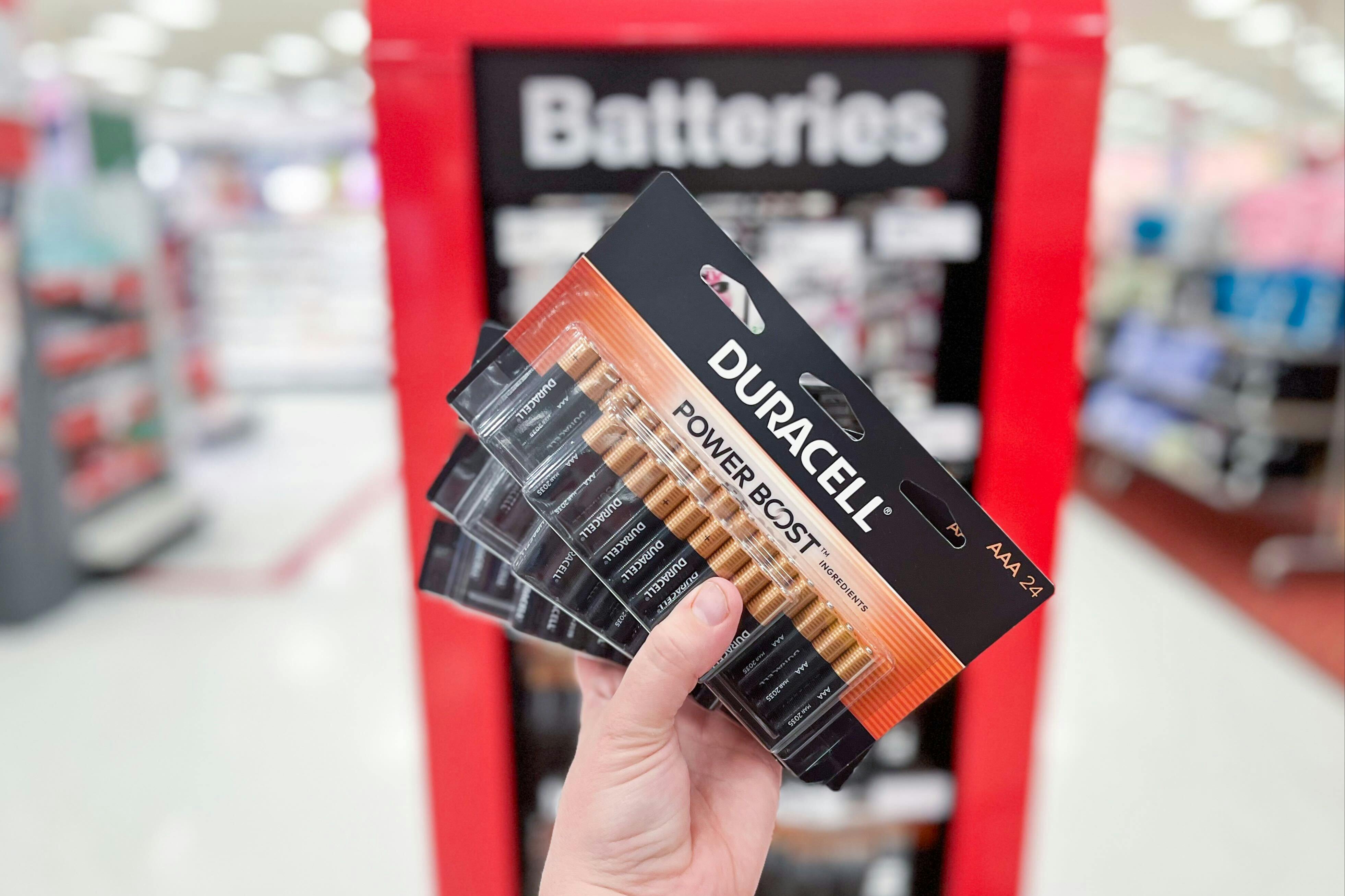 Duracell 24-Pack of AAA Batteries held up in front of batteries display in Target store