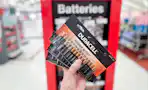 Duracell 24-Pack of AAA Batteries held up in front of batteries display in Target store