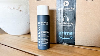 a black and white bottle next to an Amazon box