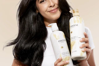 Woman holding Pantene shampoo and conditioner