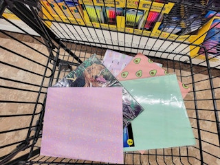 a variety of folders in a cart at dollar tree