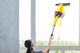 window vac squeegee B0FKHLCY3Q a person vacuums a window