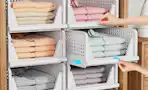 clothes folded in stackable bins on shelves