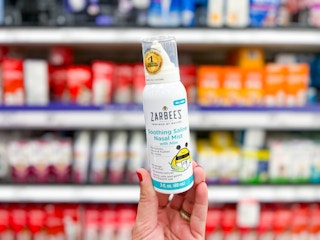 hand holding zarbee's nasal mist in front of target shelf