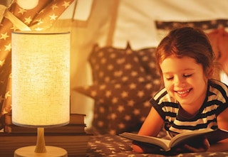 girl reading beside lamp