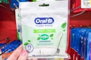 hand holding a pack of oral b floss picks at dollar general