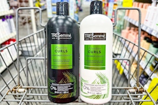 two bottles of tresemme hair care in shopping cart in store aisle
