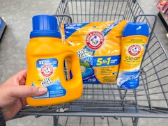 hand holding arm & hammer detergent and laundry products in walgreens cart