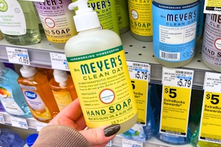 person holding a mrs meyers hand soap bottle