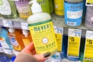 person holding a mrs meyers hand soap bottle