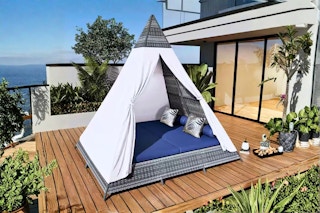 Lifestyle image of the Harper & Designs Outdoor Day Bed Tent (complete with a blue cushion)