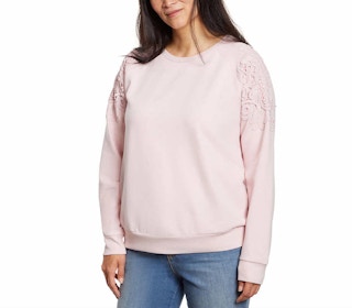 woman wearing a pink pullover with lace on sleeves