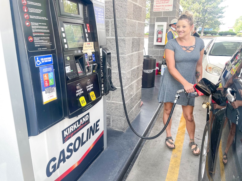 a woman pumping costco gas into car