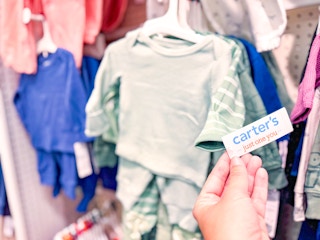 hand grabbing a carter's tag off a set at target