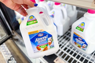 hand holding a bottle of Almond Breeze almond milk in cold area