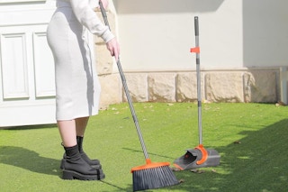 a woman using a dustpan