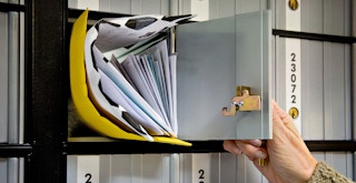 Someone opening a PO Box that is full of mail