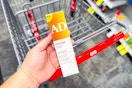 person holding a&d first aid ointment over a cvs cart