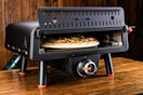 Lifestyle image of the Blackstone Pizza Oven on wooden table