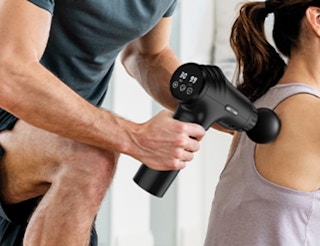 a person using a massage gun on someone's back