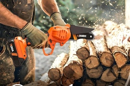 man using mini chainsaw on wood