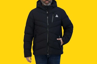 Close up shot of man wearing a black Reebok puffer coat (yellow background)