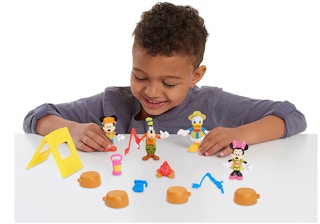 a kid playing with a mickey mouse figure set