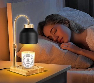 a candle warmer on a nightstand next to a person sleeping