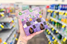 person holding air wick essential mist refills in an aisle