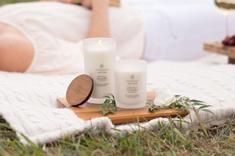 Chesapeake Bay Candle outside next to woman on ground