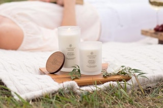 Chesapeake Bay Candle outside next to woman on ground