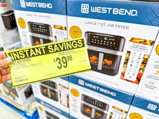 person holding a $39.98 sign in front of an air fryer