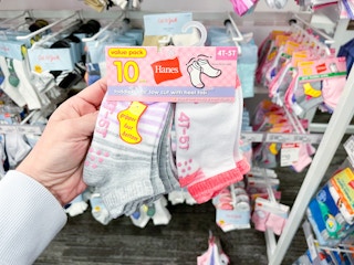 hand holding a pack of hanes toddler socks at target