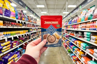 person holding a pack of blue buffalo tender shreds in an aisle