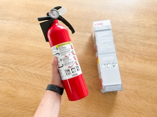 a hand holding a fire extinguisher 