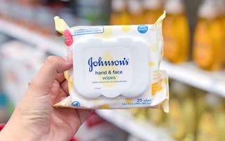 johnson's hand and face baby wipes being held by left shown against a blurry background of target shelves