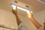 a woman using a cabinet light