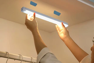a woman using a cabinet light