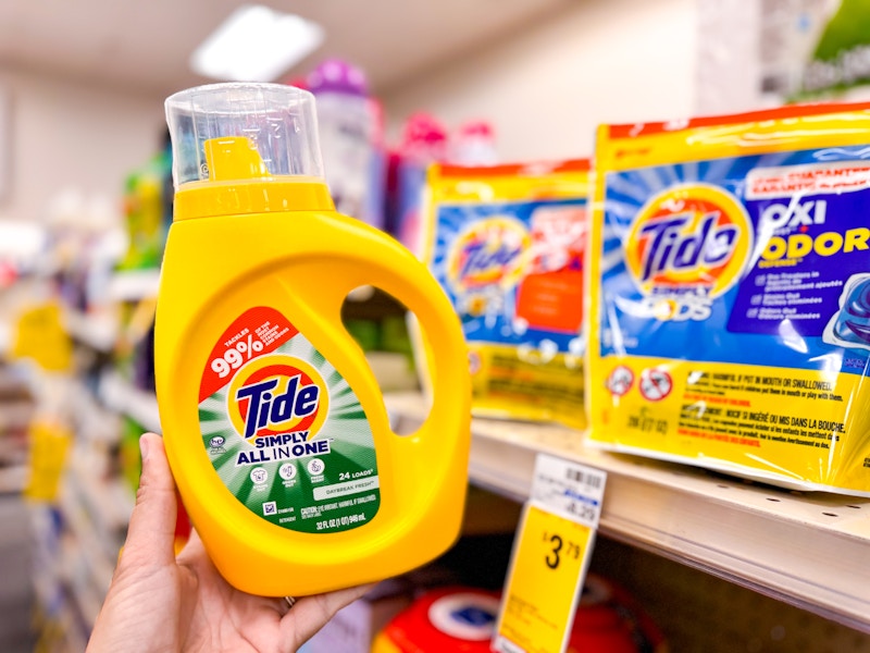 person holding a bottle of tide simply detergent by tide simply pods detergents