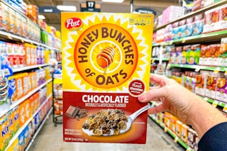 hand holding a box of post honey bunches of oats cereal